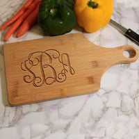 Personalized wood paddle shaped cutting board with up to three monogrammed initials