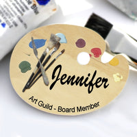 Art Palette Name Badge Wood Background with Paint Dabs on top and painting tools on left. Center and Bottom Personalization