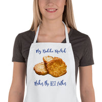Woman wearing personalized apron with picture of Latkes aka potato pancakes stating that her bubbe makes the best. Personalized with any custom text.