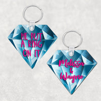 Diamond Shaped Key Ring with Blue Diamond Background 2 sided print one with names the other with He Put A Ring On It in pink text