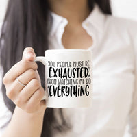 Mug side 1 says: "You people must be exhausted from watching me do everything"  Side 2 personalized with any name