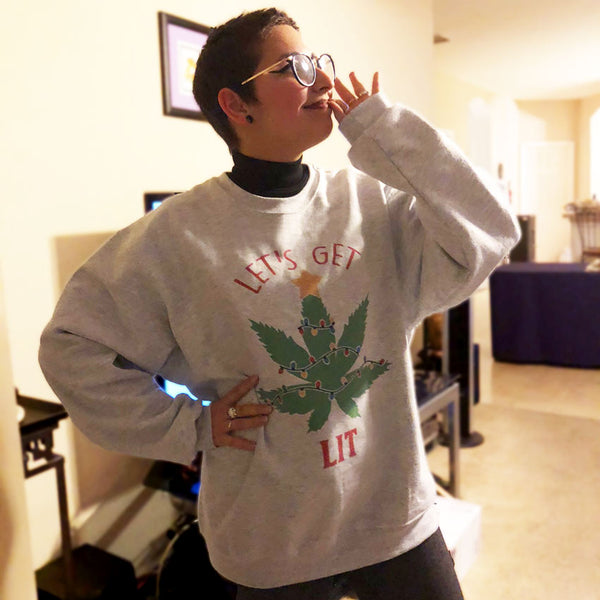 woman wearing light gray sweat shirt with pot leave as a Christmas tree shirt says lets get lit