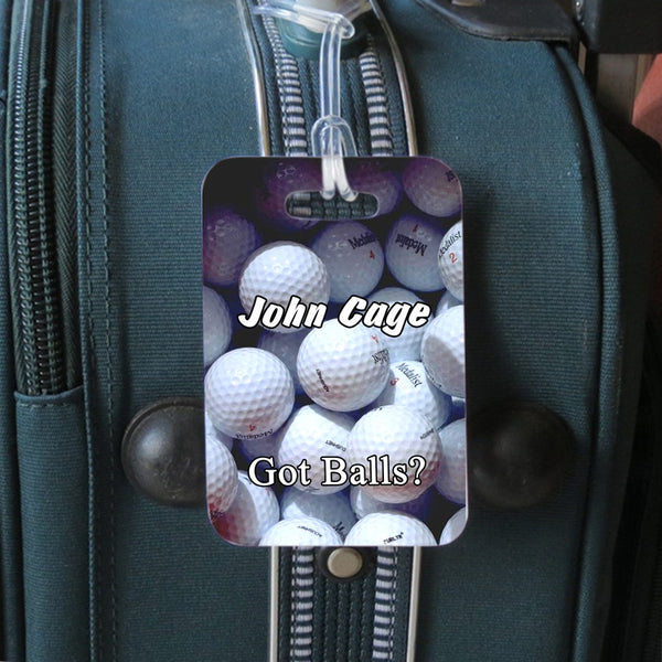 luggage tag hanging from luggage with got balls design for golfers
