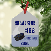 gift tag shaped ornament with hockey puck and four lines of custom text.