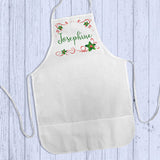 Apron shown lying flat on wood Personalized Apron with holly and ribbon rectangle framing to any name. 