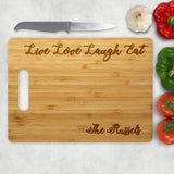 Live Love Laugh Eat is engraved across the top of this bamboo cutting board with inner loop hole handle bamboo cutting board and your name along the bottom right
