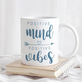Mug says Positive Mind Positive Vibes with arrow containing heart between the two phrases
