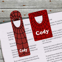 Both sizes of spider web bookmark shown holding a book page.